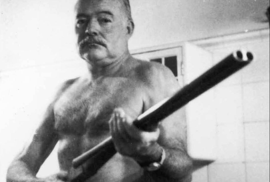 Ernest Hemingway, posing in 1952 with the Scott double-barrelled duck-hunting shotgun he - most likely - used to kill himself almost ten years later