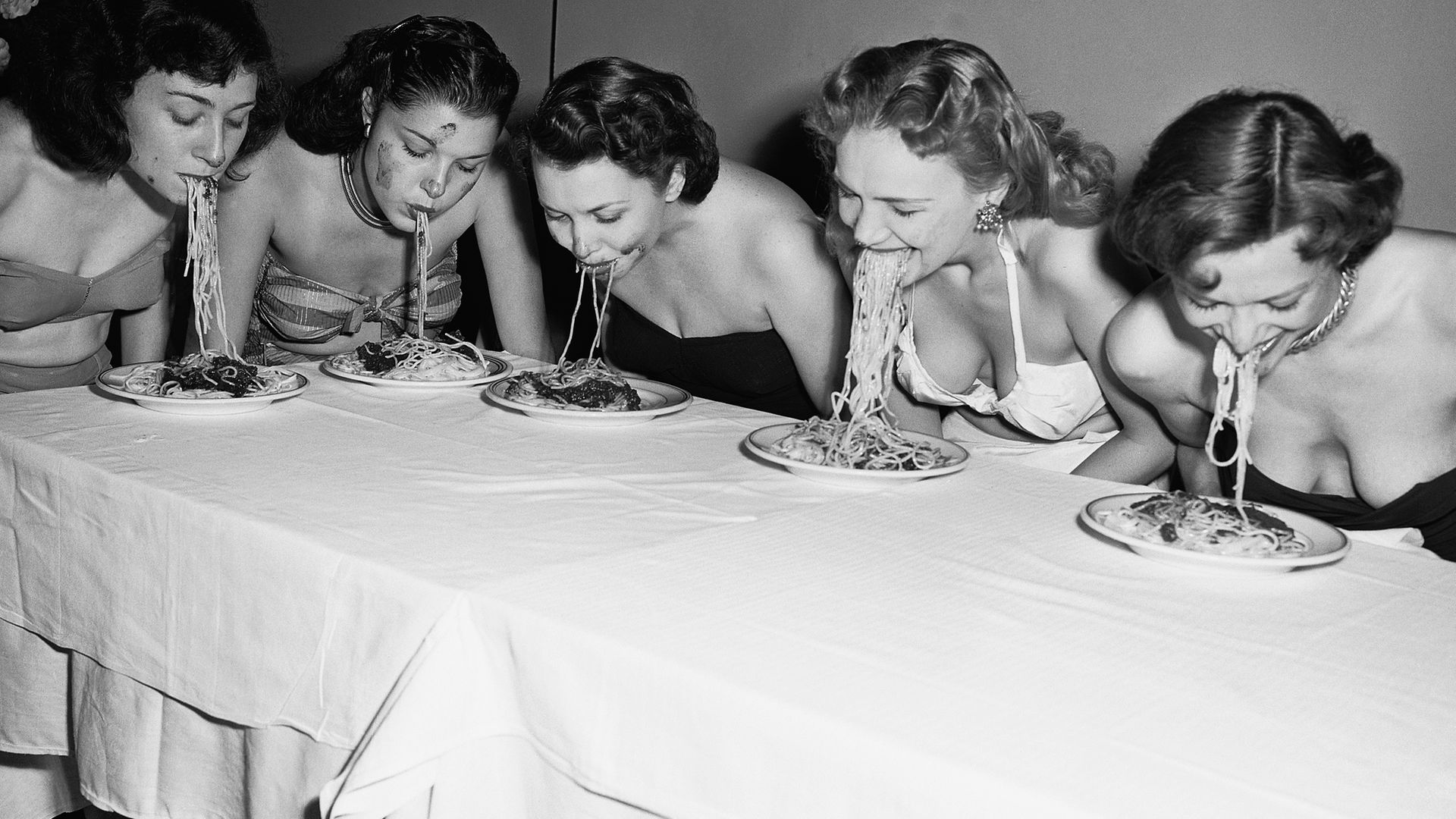 Five Broadway show girls participated in a 'spaghetti swooshing' contest, where they had to eat a plate of spaghetti and sauce without using their hands - Credit: Bettmann Archive