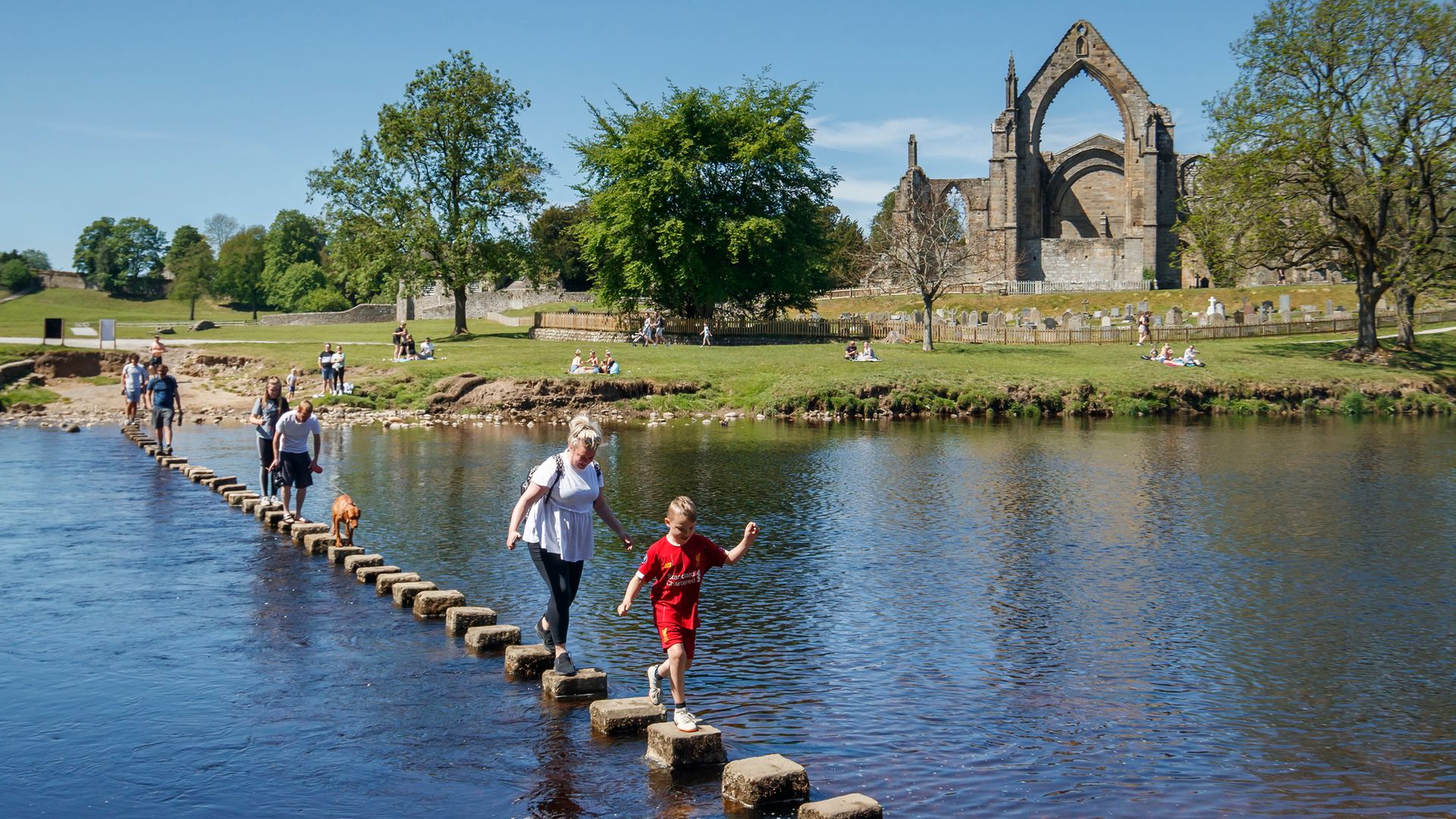 People enjoy the weather at Bolton Abbey in North Yorkshire as people flocked to parks and beaches after the first lockdown measures eased - Credit: PA