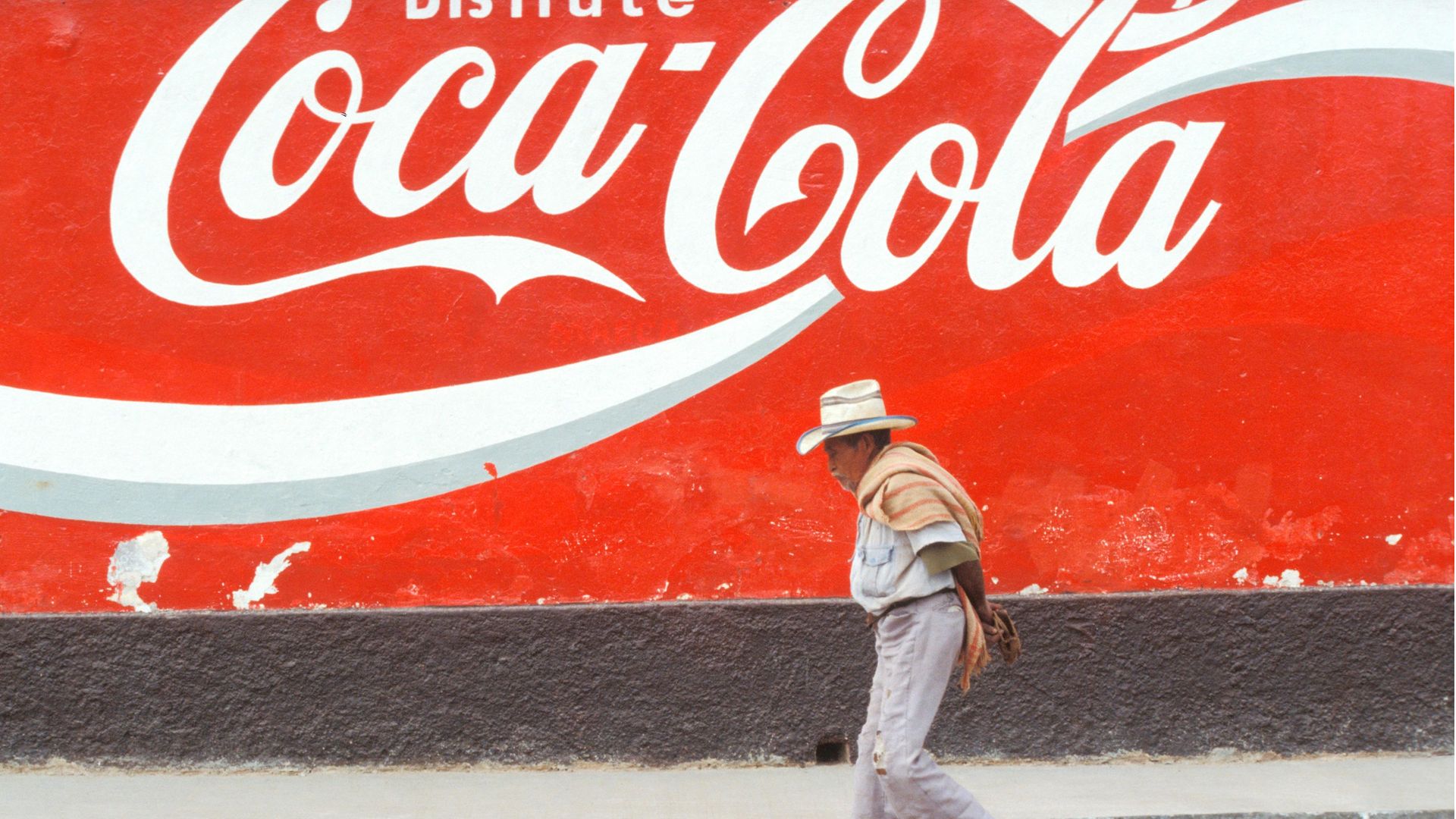 A man walks past a Coca-Cola advert in San Cristobal de las Casas, Mexico - Credit: Riccardo Lombardo/Reda&Co/Universal Images Group via Getty Images