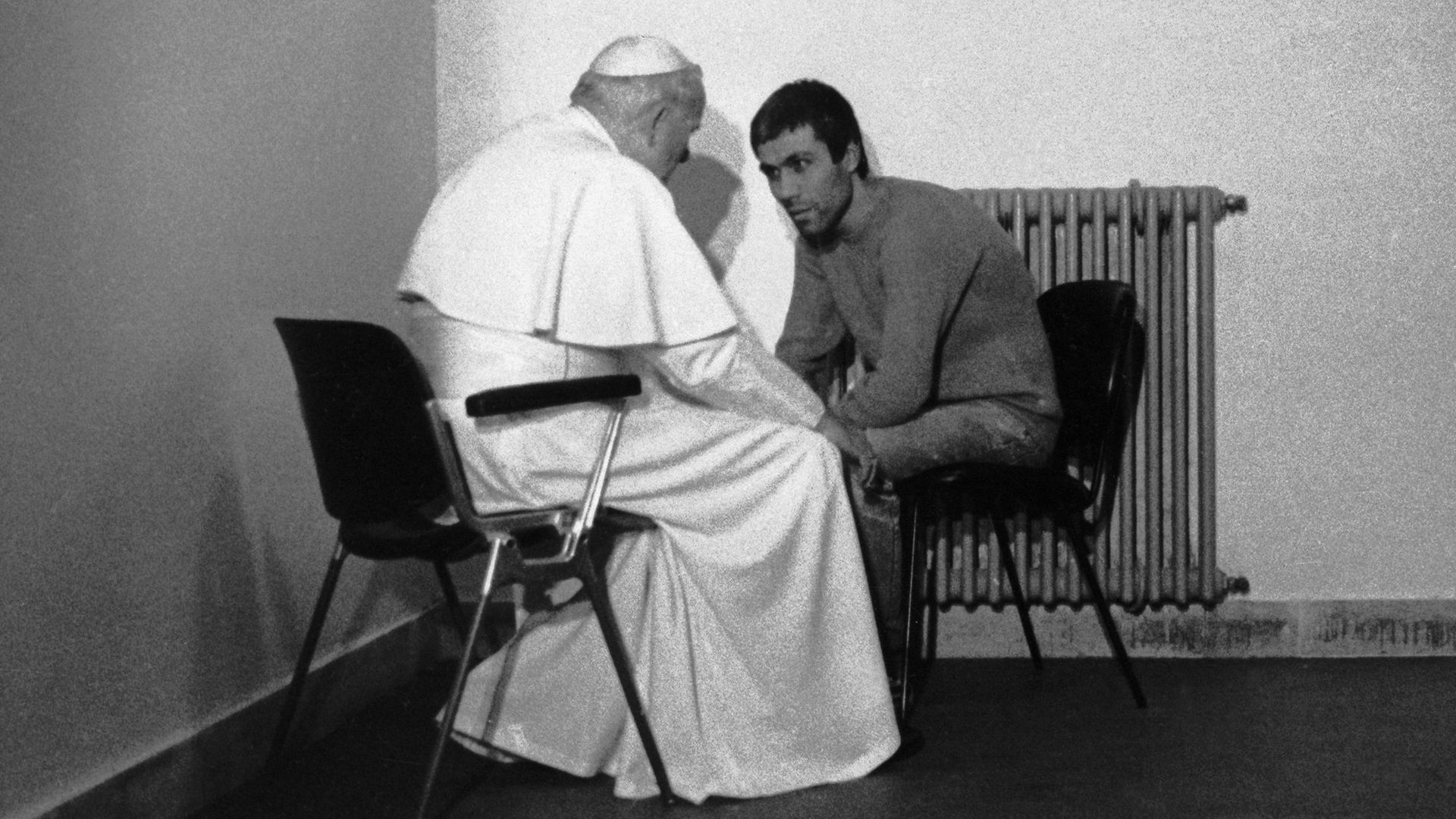Pope John Paul II talks with Turkish terrorist Mehmet Ali Agca as the Pontiff meets him inside his cell at Rome's Rabibbia jail - Credit: Bettmann Archive