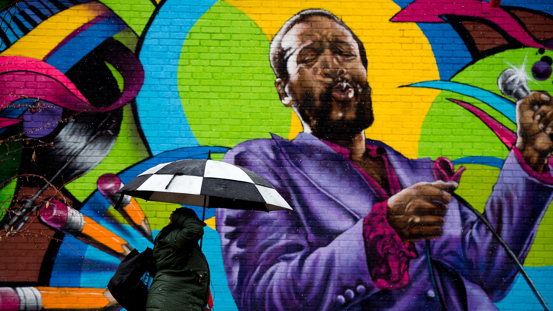 A woman walks past local artist Aniekan Udofia's mural of Marvin Gaye in Washington, DC - Credit: Photo by Andrew Harnik for The Washington Post via Getty Images