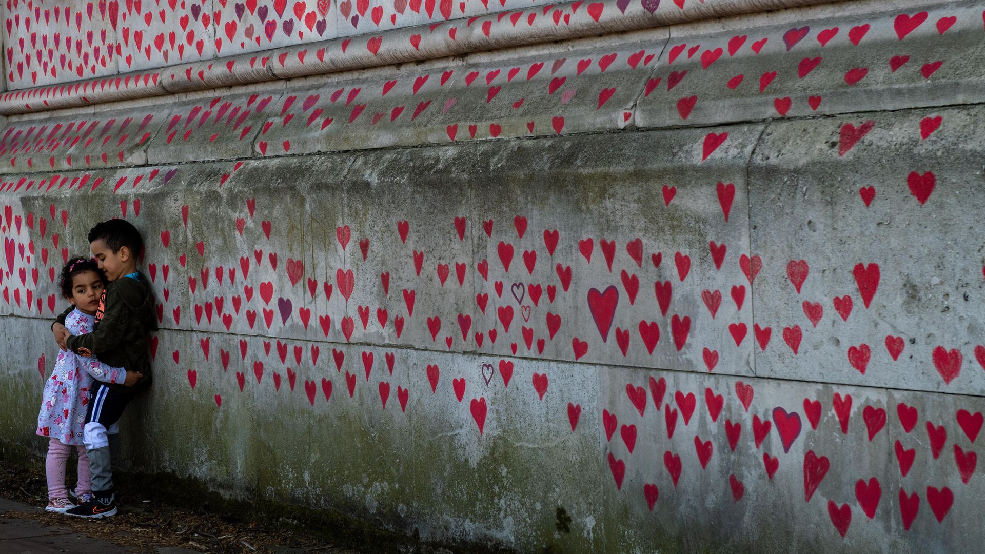 Brother and sister Amira, three, and Adem Atia, four, at the Covid Memorial Wall, on the Embankment opposite the Houses of Parliament - Credit: Getty Images