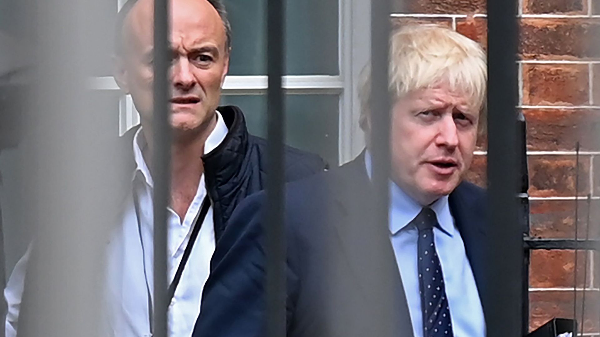 Britain's Prime Minister Boris Johnson (R) and former special advisor Dominic Cummings leave from the rear of Downing Street - Credit: AFP via Getty Images