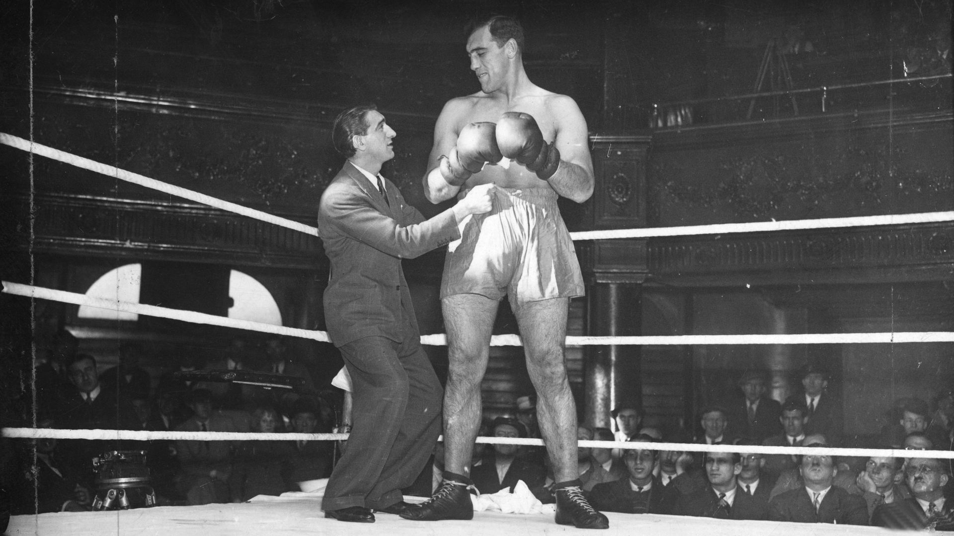 Primo Carnera at The Ring venue, Blackfriars Road, London, having his shorts adjusted, in 1937 - Credit: Getty Images