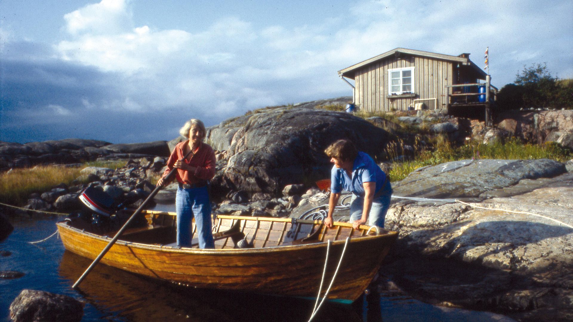 Tove Jansson and partner Tuulikki Pietilä on the island of Klovharun with their cabin behind them - Credit: © Moomin Characters™