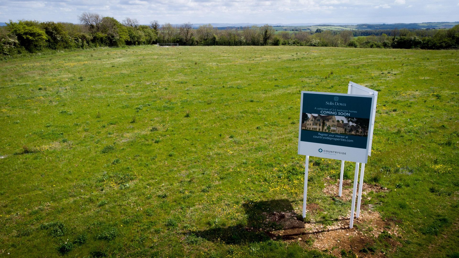 SIGN OF THINGS TO COME: A property developer’s board advertises new houses that are planned to be built on green belt land on the edge of Bath - Credit: Matt Cardy