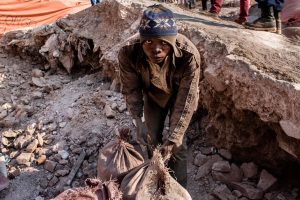 A young miner in Kolwezi, in the Democratic Republic of Congo, fastens bags of cobalt, a vital component in many modern electrical devices. Photo: Sebastian Meyer/ Corbis via Getty Images