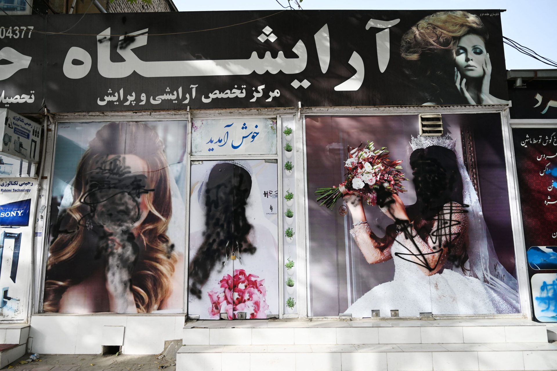 Images of women on the facade of a beauty salon in Shar-e-Naw, Kabul are defaced as the Taliban arrive to retake the city. Photograph: Wakil Koshar/AFP/Getty Images.