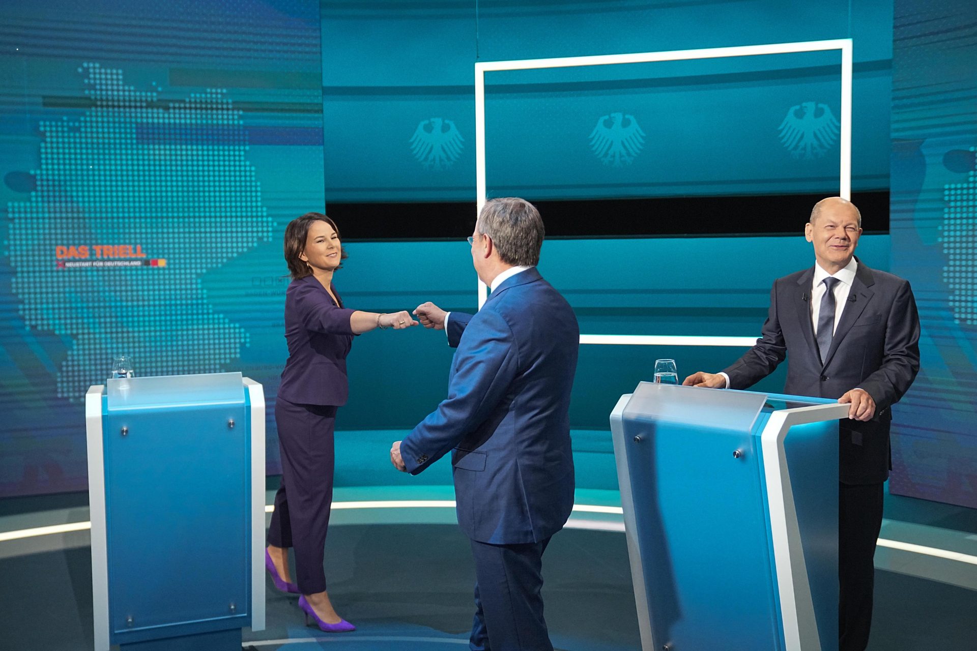 Chancellor candidate Annalena Baerbock of the Greens fistbumps the SPD’s Olaf Scholz after their first TV debate with Armin Laschet of the CDU. Photo: Michael Kappeler/Pool/Getty Images.