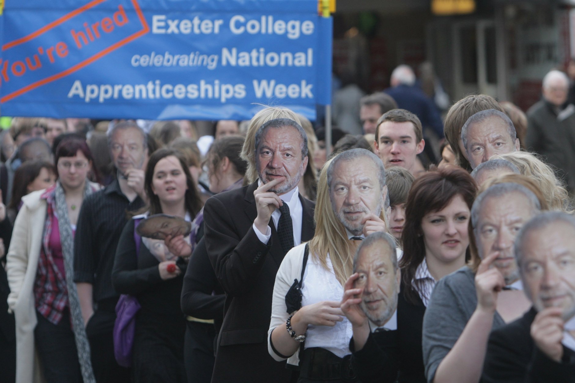 Students wearing Sir Alan Sugar masks at the launch of a campaign to boost the take-up of apprenticeships in the UK. Yet despite a series of reforms, the scheme has proved costly and inefficient. Photo: Matt Cardy/Getty Images.
