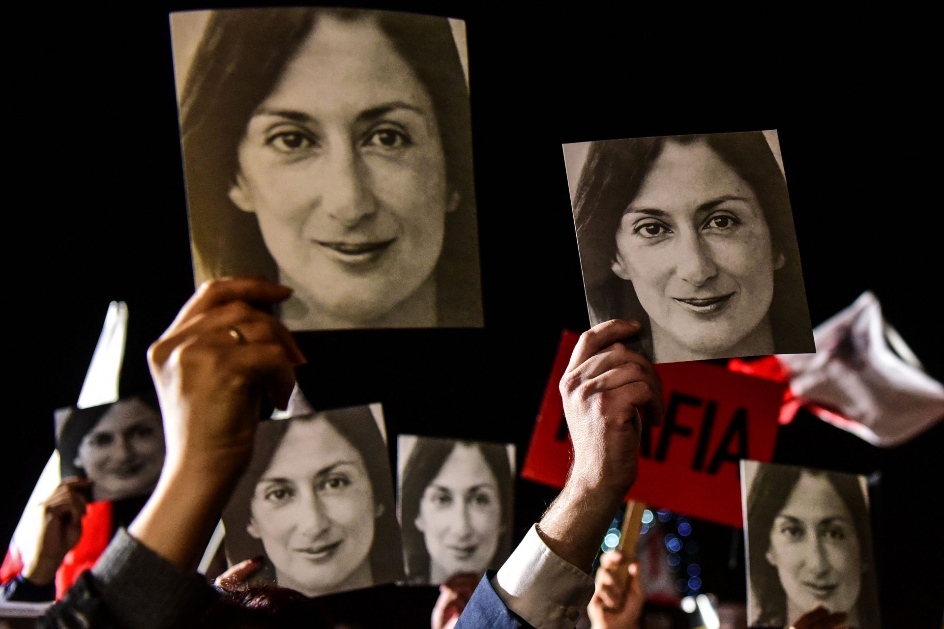 People holding placards reading "Mafia Government" and photos of killed journalist Daphne Caruana Galizia outside the office of the prime minister in Valletta, Malta. (Photo by STRINGER/AFP via Getty Images)