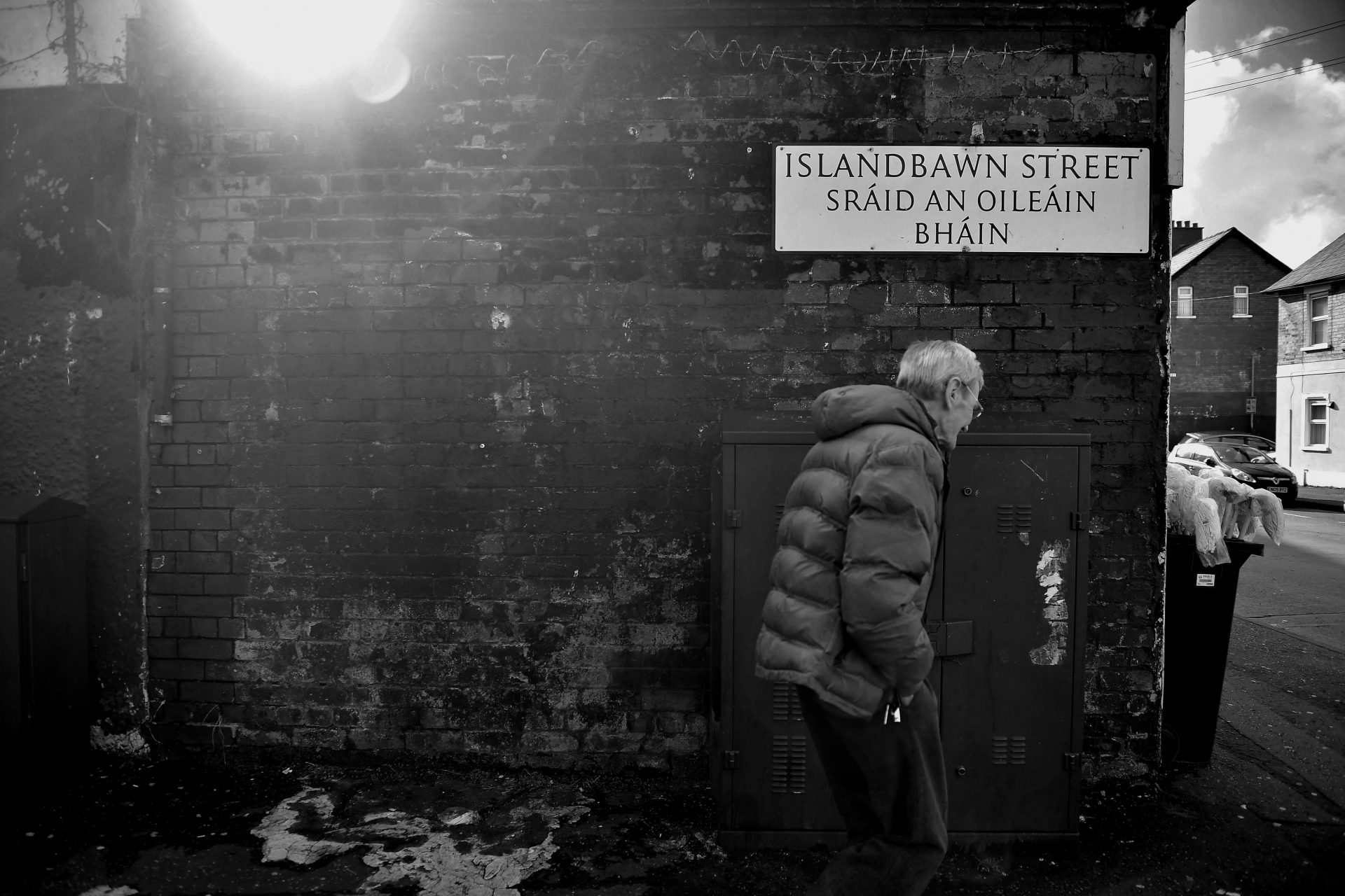 A man walks past a dual Irish-English language street sign in Belfast. Photo: Charles McQuillan/Getty Images.
