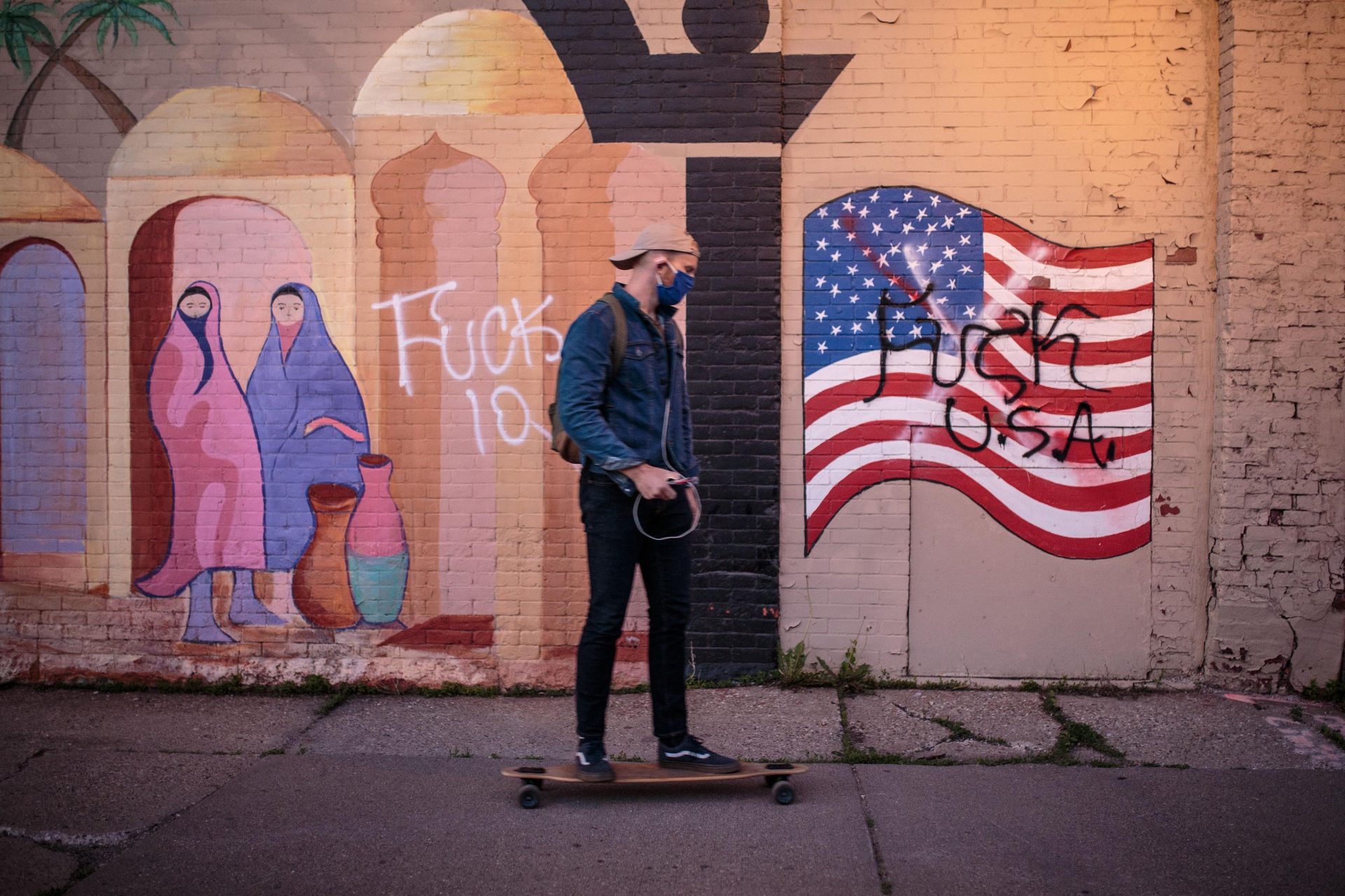 A skateboarder passes graffiti on a mural of a US flag in Minneapolis, Minnesota. Photo: Kerem Yucel/
AFP via Getty Images.