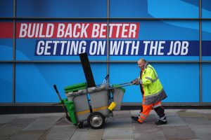 Who is most trusted not to make a mess? A street cleaner walks past a poster at the Conservative Party conference in Manchester this week. Photo by Christopher Furlong/Getty