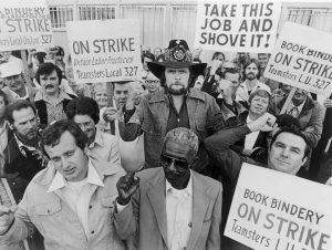 Country singer Johnny Paycheck holds a sign bearing the title of his most famous song during a 1977 strike by bookbinders. Photo: Getty Images
