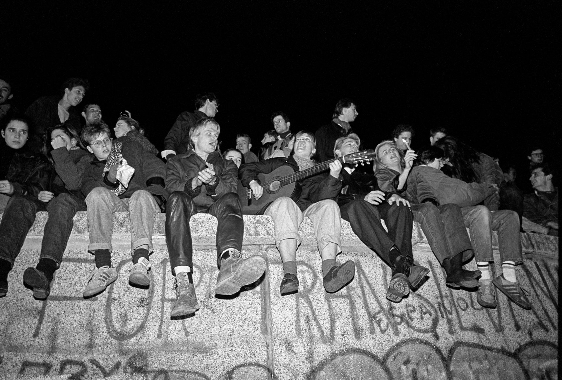 Young Germans singing from atop the Berlin Wall on the evening of November 9, 1989. Photo: ullstein bild via Getty Images.