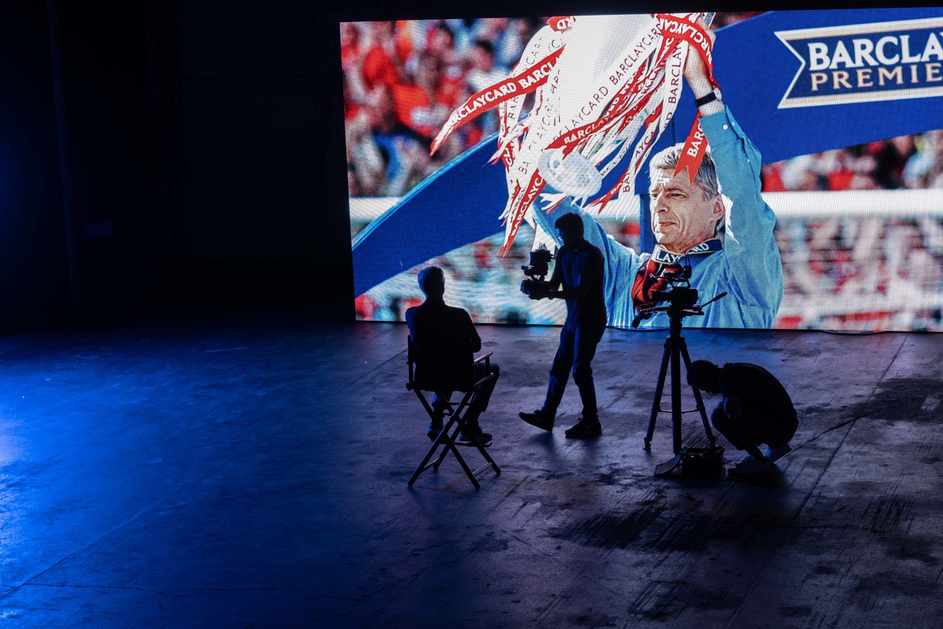 Arsene Wenger watches documentary footage of himself lifting the Premier League trophy during the filming of Invincible. Photo: Wlad Simitch.