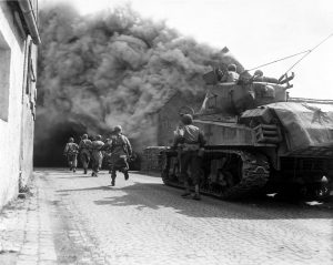 Soldiers of the 55th Armored Infantry Battalion and tank of the 22nd Tank Battalion, move through a smoke filled street, Wernberg, Germany. Photograph: Getty Images.