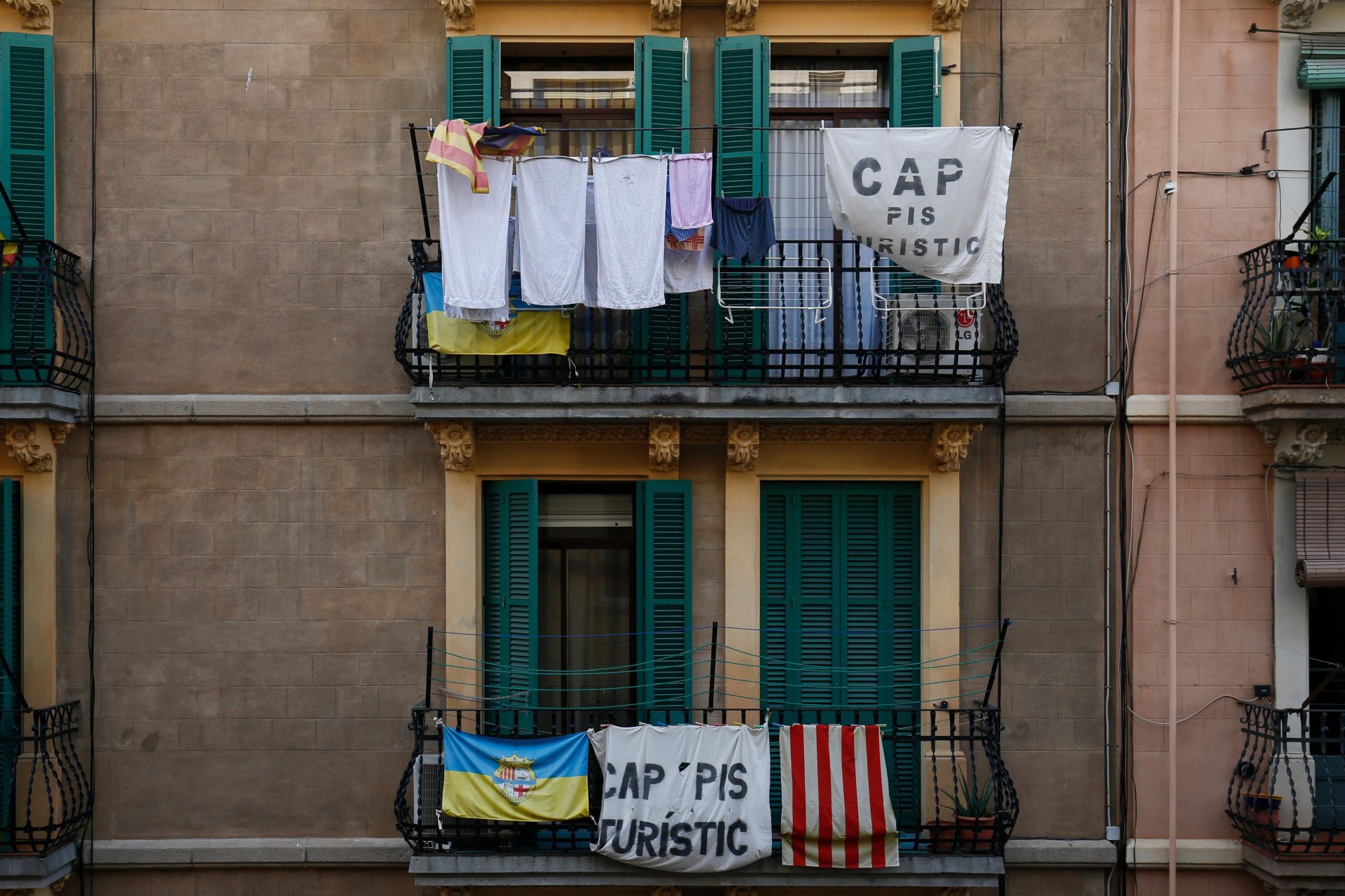 Banners reading “No tourist flats” hang from a balcony to protest against holiday rental apartments for tourists in the Barcelona suburb of Barceloneta. Photo: PAU BARRENA/AFP via Getty