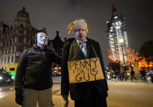 People with a Boris Johnson cardboard cut-out taking part in the Million Mask March 2021 in Parliament Square, London. Photograph: PA Images.