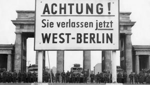 Guards stand at the Brandenburg Gate, as the Berlin Wall goes up behind them, in August 1961. Photo: ullstein bild via Getty Images.