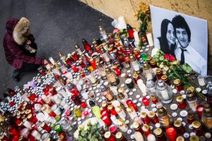 A mourner places a candle in front of a portrait of murdered Slovak investigative journalist Jan Kuciak and his girlfriend Martina Kusnirova in the centre of Bratislava in 2018. Photo: Vladimir Simicek/AFP/Getty Images.