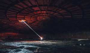 : An underground water reservoir in Tbilisi, with a shaft of light striking photographer Davit Tabagari.