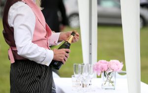 A steward pours glasses of champagne during day two of Royal Ascot at Ascot Racecourse. Photo: Nigel French/PA Archive/PA Images. 