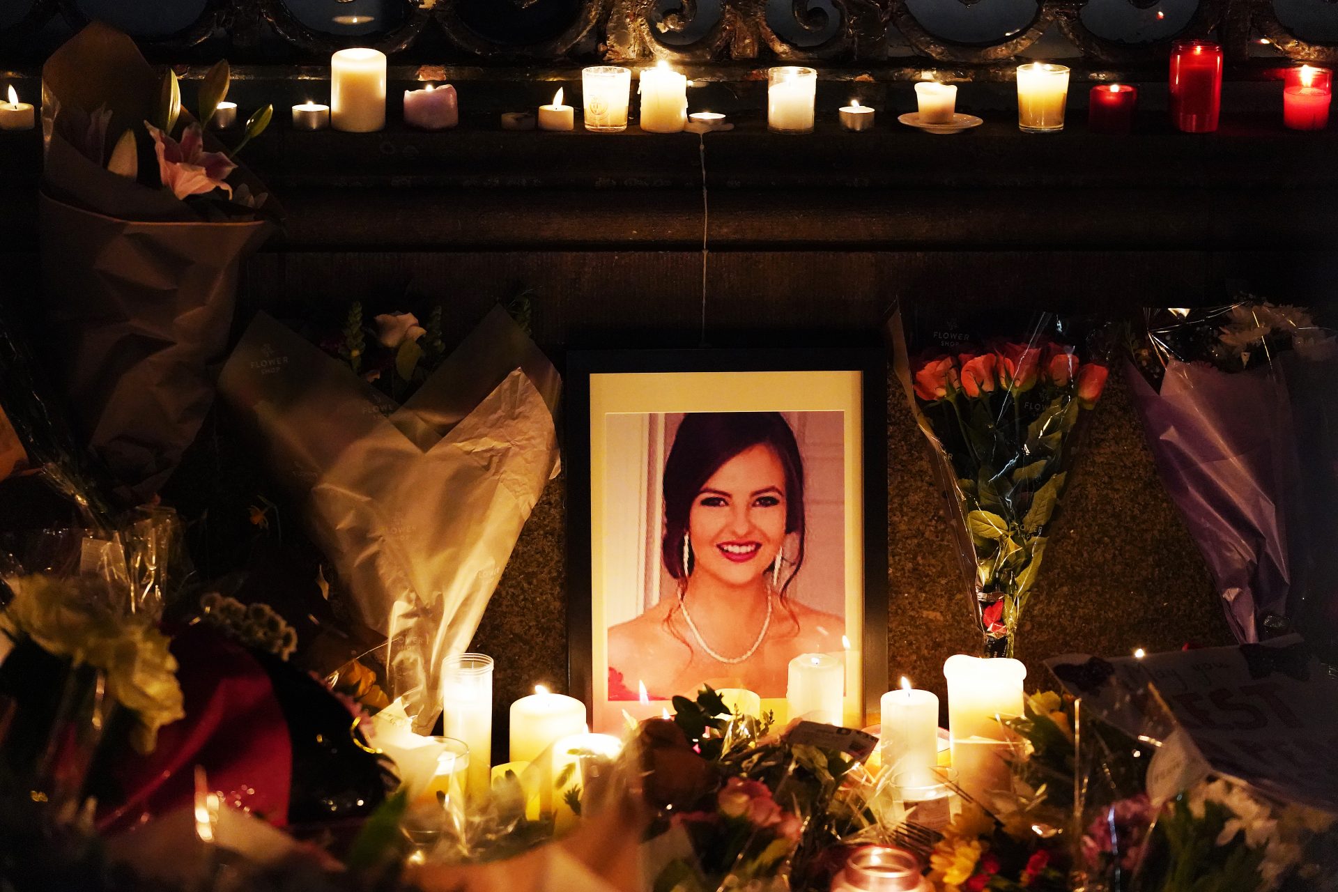 A photograph of Ashling Murphy among flowers and candles during a vigil. Photo:  Brian Lawless/PA Wire/PA Images.