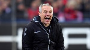 Christian Streich uses a loudhailer to address Freiburg fans after their final game at the Dreisamstadion. Photo: Matthias Hangst/Bongarts