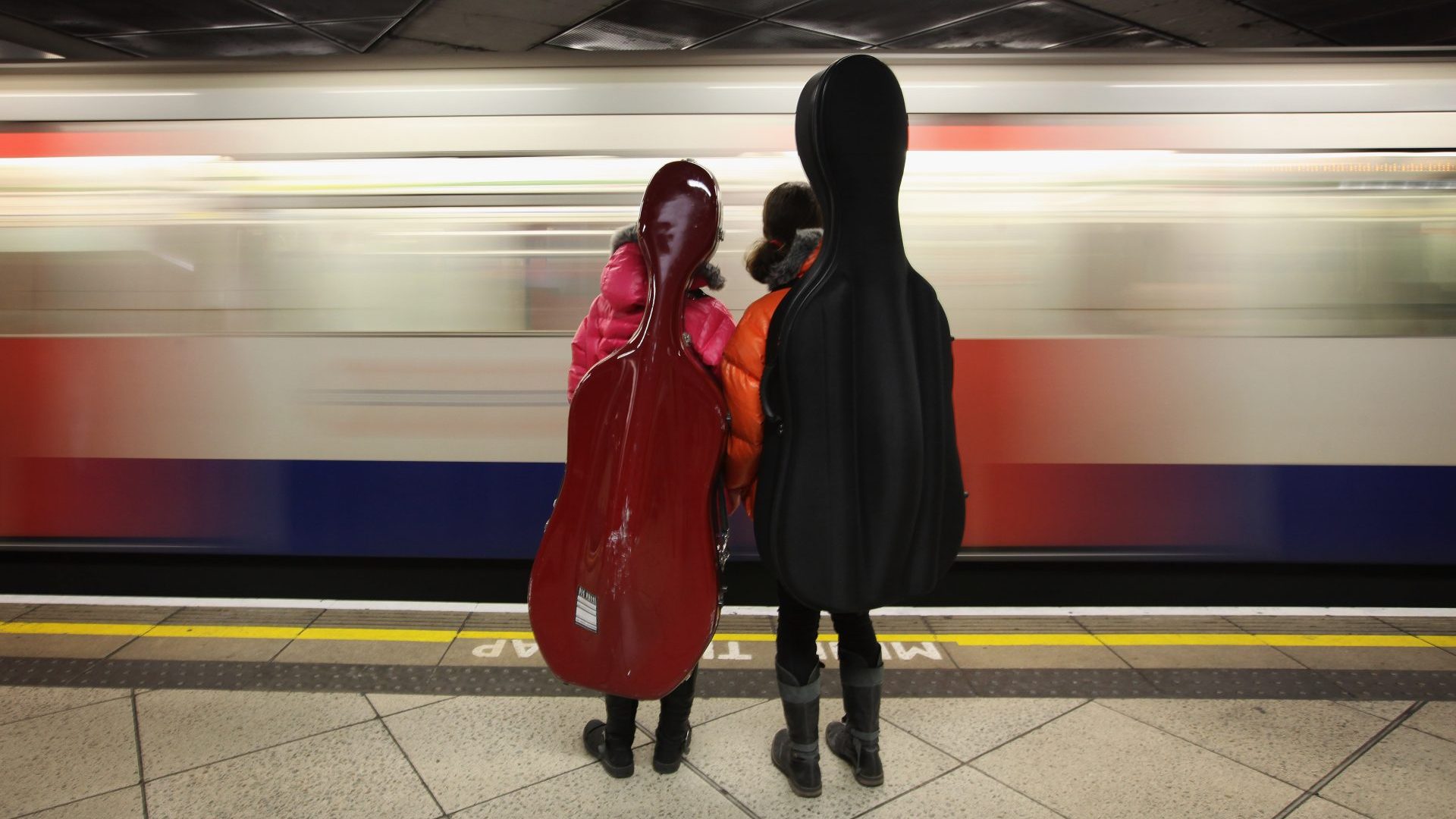 Two girls carrying cellos wait for a train on London Underground's Westminster Station (Photo by Dan Kitwood/Getty Images)