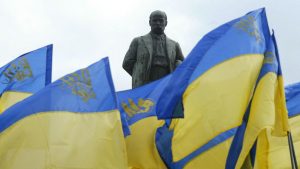 Ukrainian flags are seen in front of the monument of Ukrainian poet Taras Shevchenko (1814-1861) in Kiev during an opposition rally marking the 190th anniversary of his birth (Photo by SERGEI SUPINSKY/AFP via Getty Images)