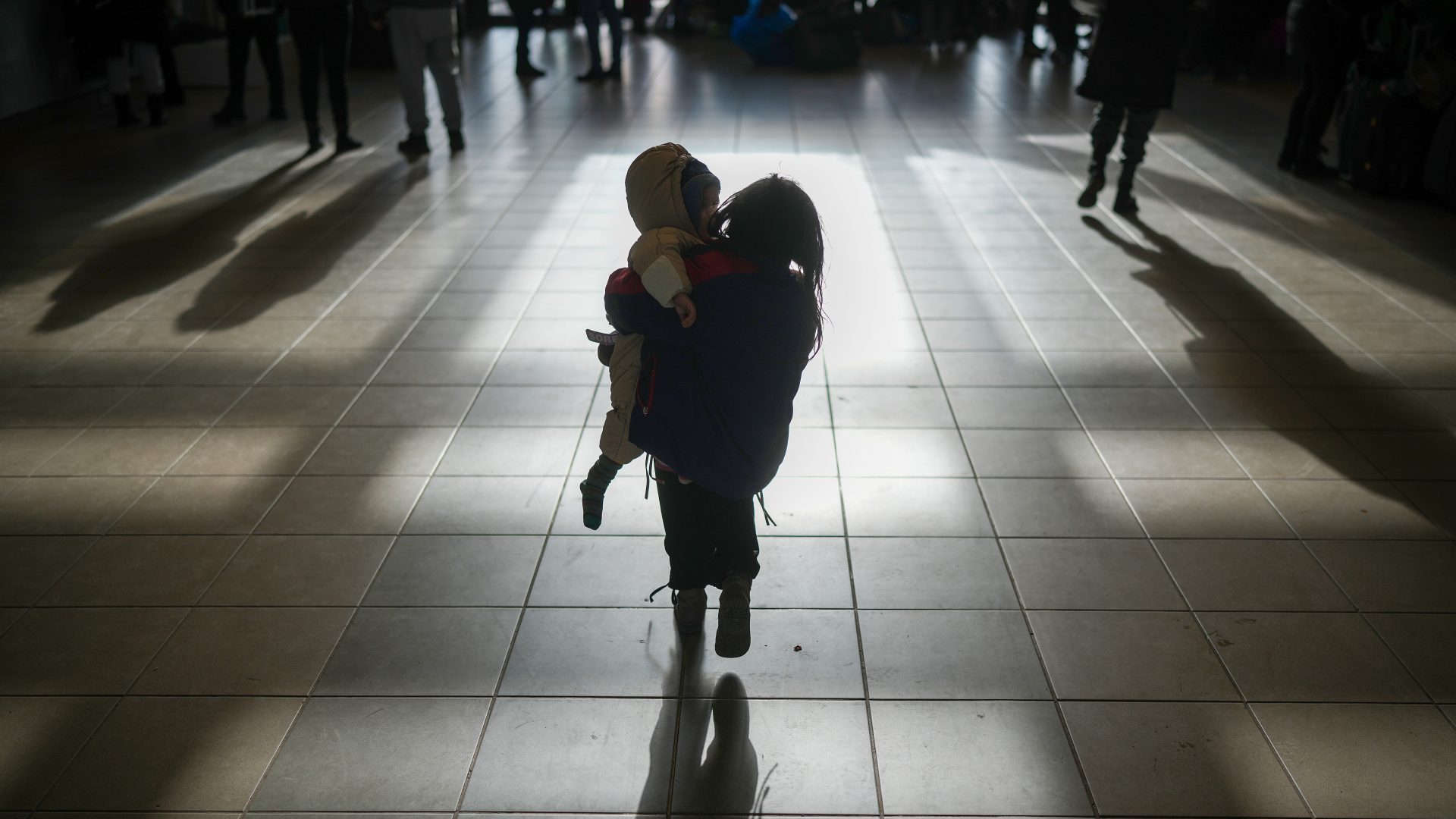 A refugee girl carries a sibling after arriving at the Hungarian border town of Zahony on a train that has come from Ukraine. Photo: Christopher Furlong/Getty Images