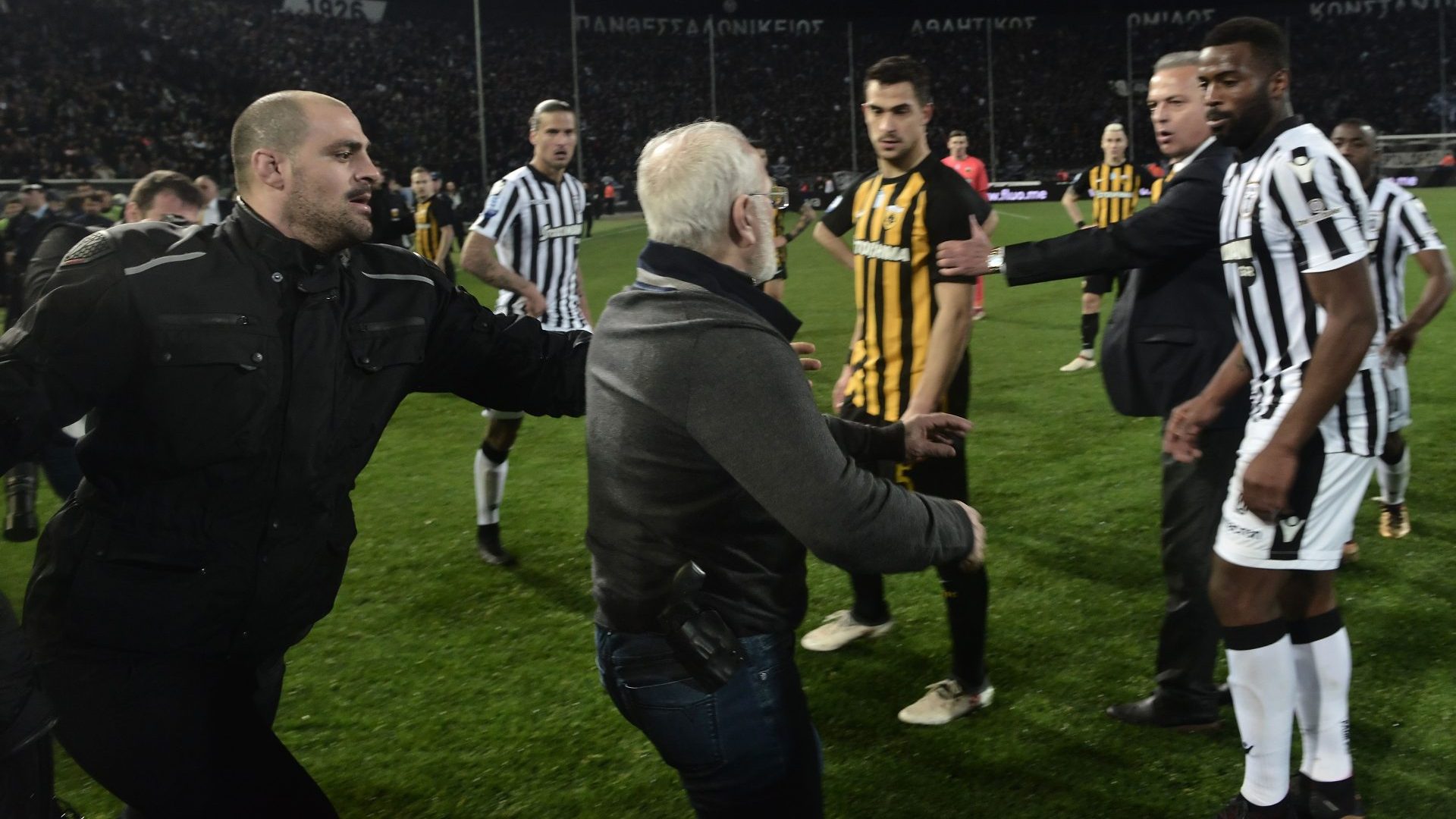 Ivan Savvidis (centre) goes on to the pitch carrying a handgun in his waistband during a match between PAOK Thessaloniki and AEK Athens (Photo: AFP/Getty)