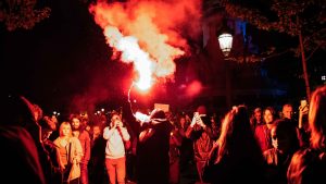 A Parisian lights a flare at the start 
of protests against the re-election 
of Emmanuel Macron as president. Photo: Jerome Gilles/NurPhoto/Getty