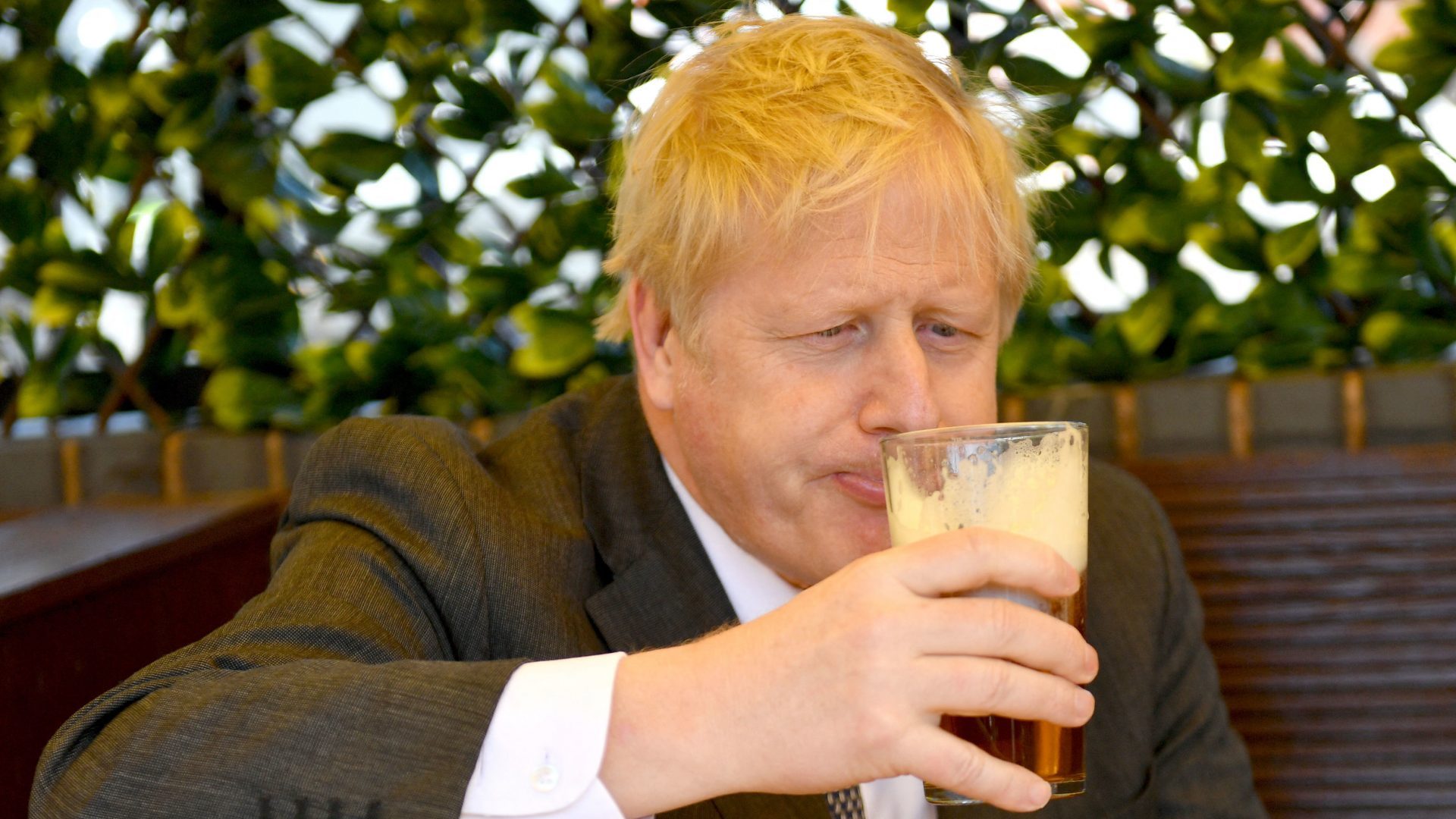 Boris Johnson enjoys another drink while at work – in this case, during campaigning for the local elections in April 2021. Photo: Jacob King/Getty