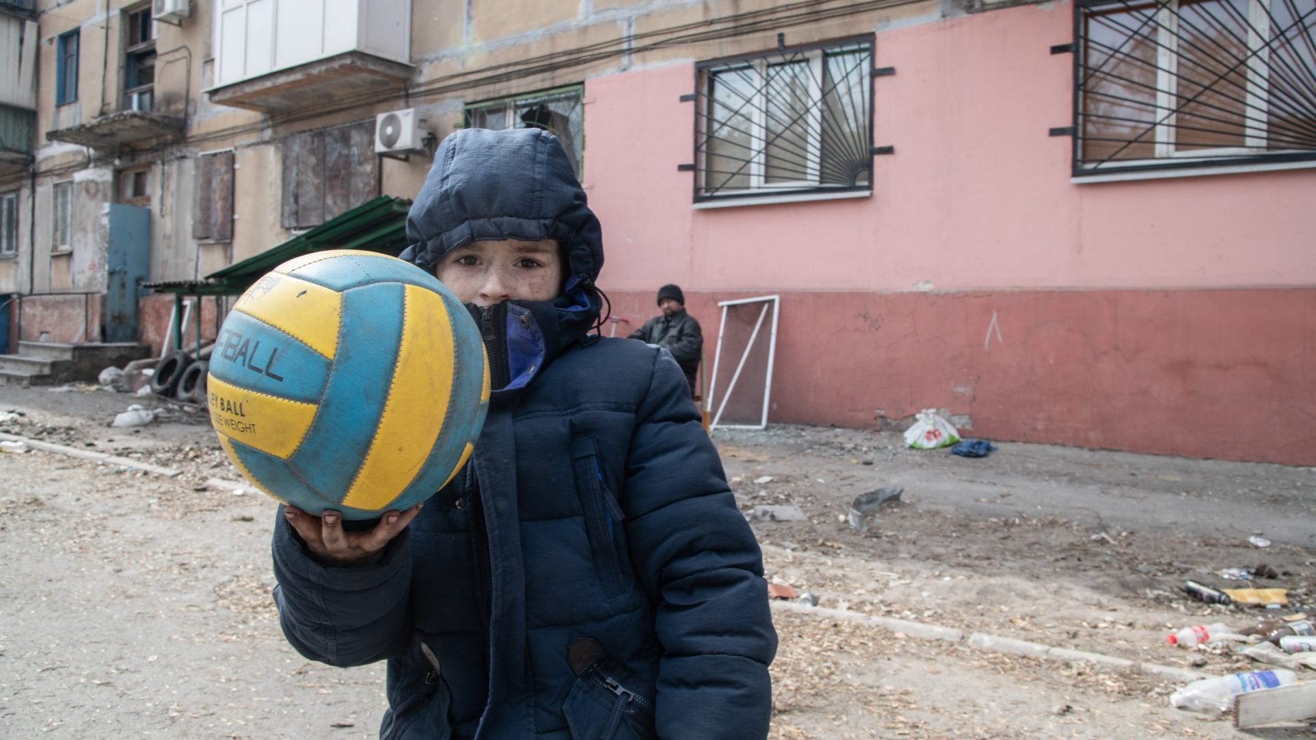 A boy in Mariupol shows off his football outside his damaged home, where he 
now lives in the basement (Photo: Maximilian Clarke/
SOPA Images)