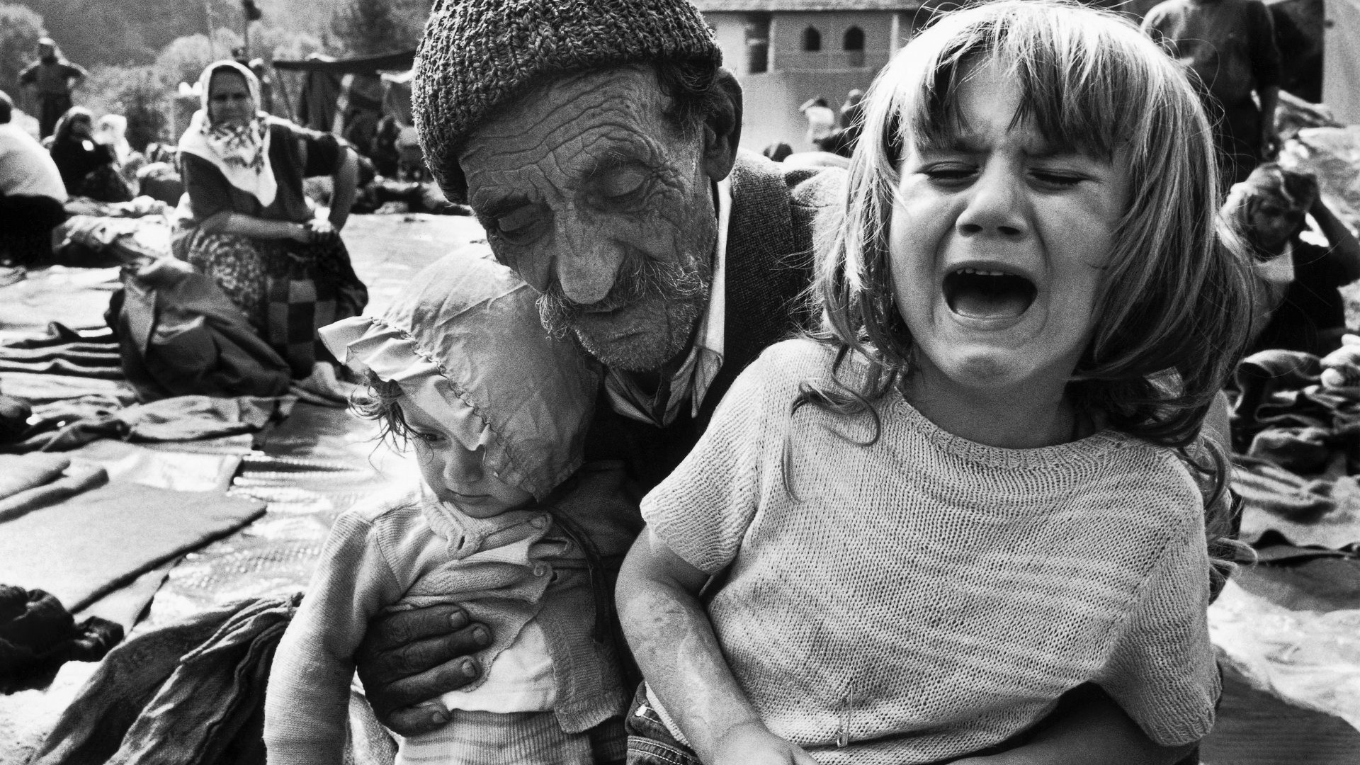 A Bosnian man holds his exhausted granddaughters after a long journey on foot to a UN refugee 
camp at Kladanj after being forced to flee their home amid Serbian ethnic cleansing. The girls’ parents had not been found. Photo: David Turnley/Corbis/VCG/
Getty