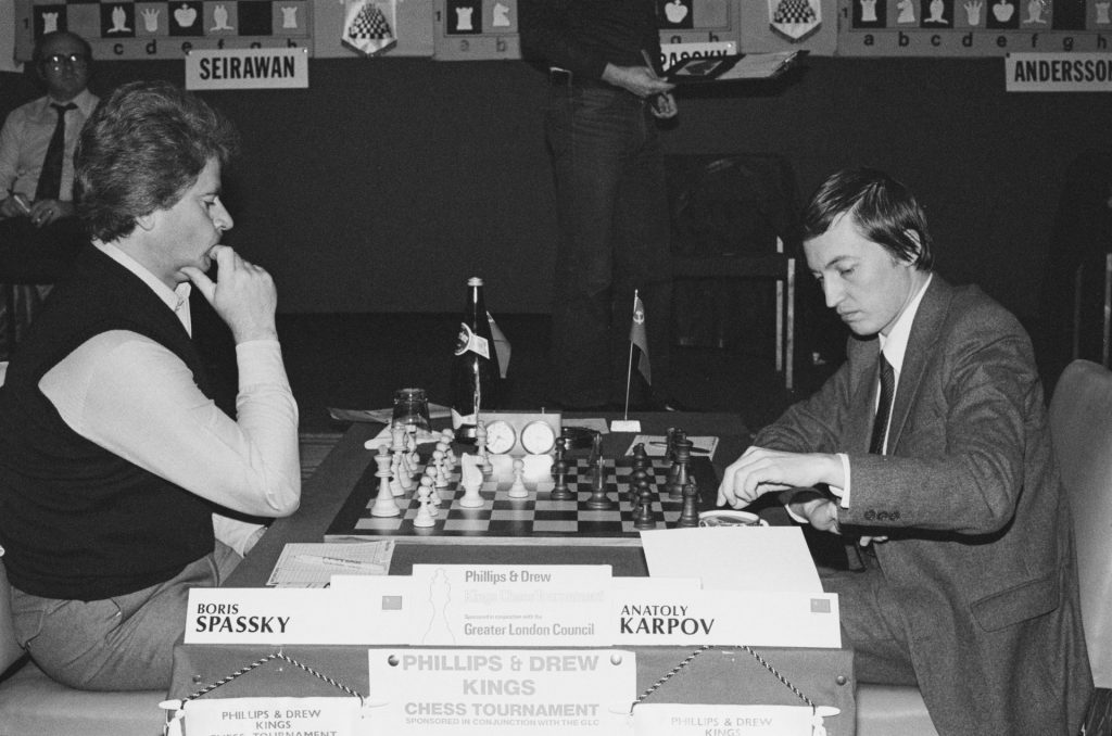 Russian chess grandmasters Boris Spassky, right, and Anatoly Karpov, left,  shake hands the news