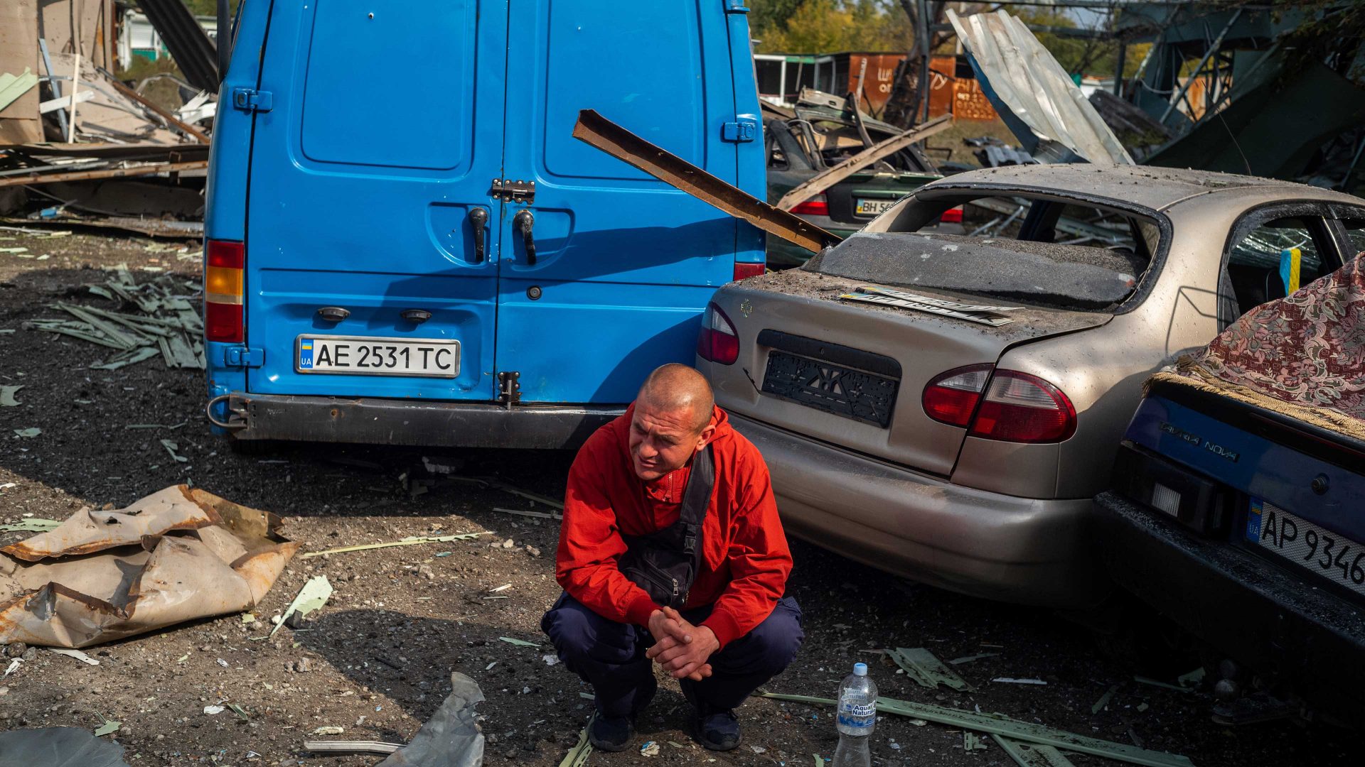 A Ukrainian sits amid the destruction on the scene of a Russian missile strike on a civilian convoy in 
Zaporizhzhia, in which 30 people died. Photo: Wojciech Grzedzinski/
Washington Post