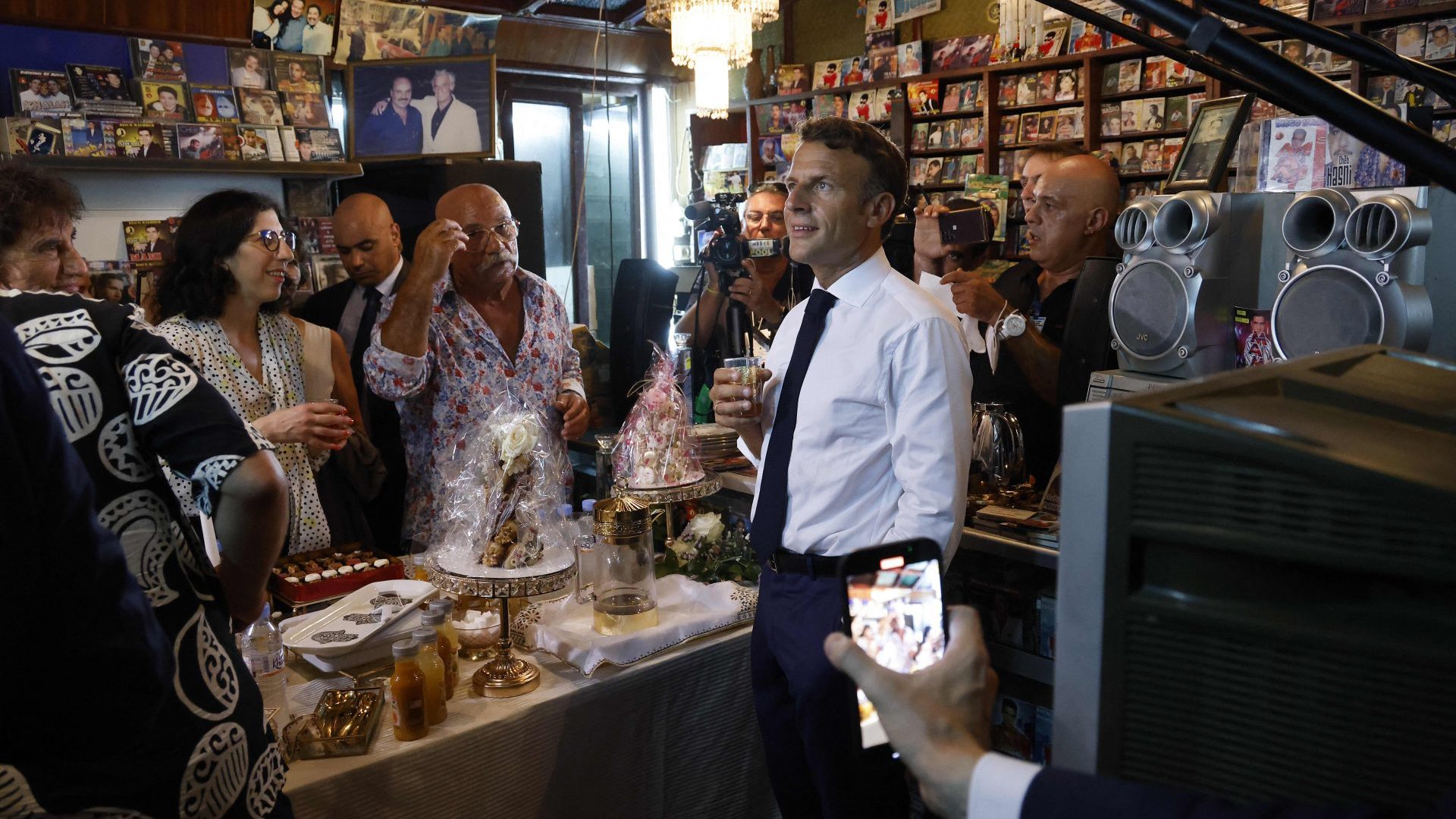 France's President Emmanuel Macron looks on during his visit at the disco Maghreb Shopin, the mythical label of rai music, next to its owner, Boualem Benhaoua and France's former minister and Arab World Institute President Jack Lang in Oran in August (Photo by LUDOVIC MARIN/AFP via Getty Images)