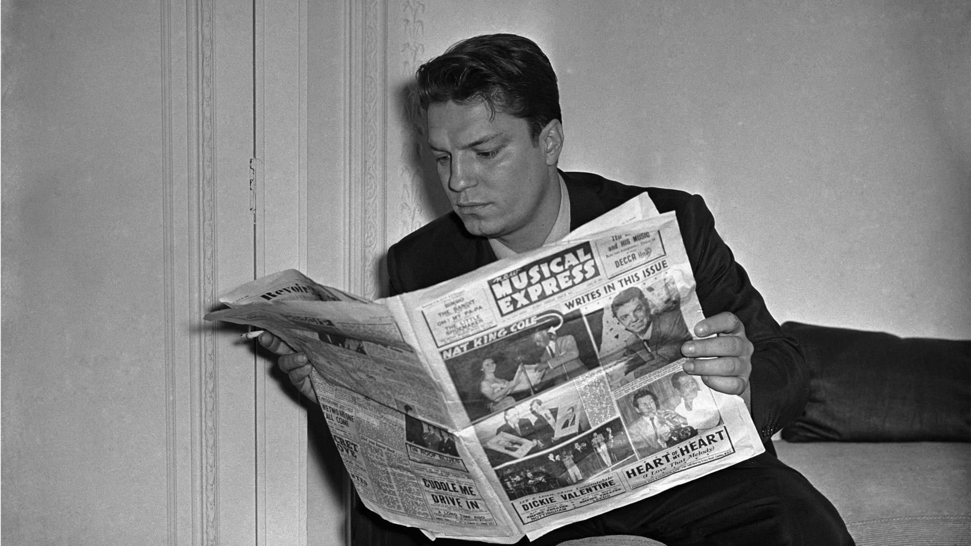American singer Guy 
Mitchell reads the NME in 1956, not long after it launched the singles chart. Photo: Harry Hammond/V&A 
Images/Getty