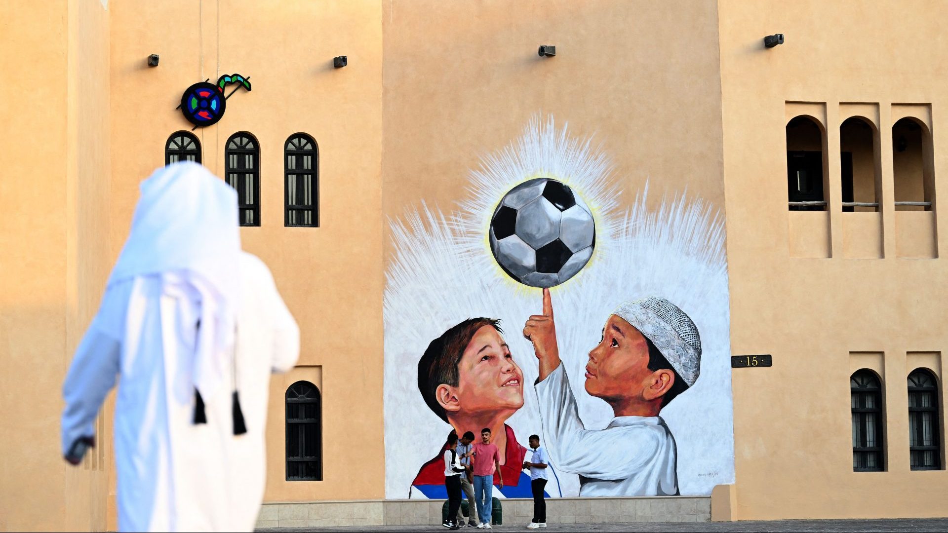 People walk past a mural in Doha on November 8, 2022, ahead of the Qatar 2022 FIFA World Cup football tournament. Photo: GABRIEL BOUYS/AFP via Getty Images