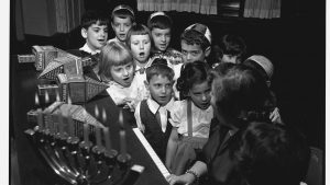 Children sing during 
Hanukkah celebrations. While singing, they spin 
dreidels with messages written on their sides. Photo: Hulton-Deutsch 
Collection/Corbis