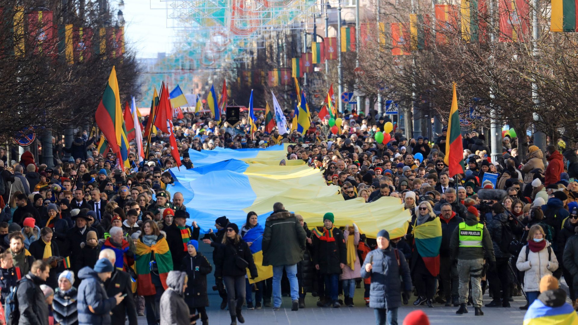 People walk with a giant many meter-long Ukrainian flag to protest against the Russian invasion of Ukraine during a celebration of Lithuania's independence in Vilnius, Lithuania. Photo: PETRAS MALUKAS/AFP via Getty Images