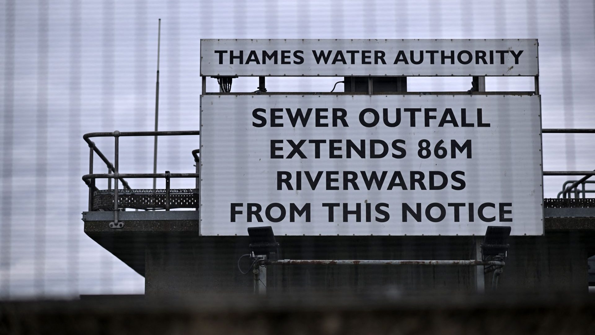A sign warning of a 'Sewage Outfall' is pictured at the Thames Water Long Reach water treatment facility on the banks of the Thames estuary in Dartford (Photo by BEN STANSALL/AFP via Getty Images)