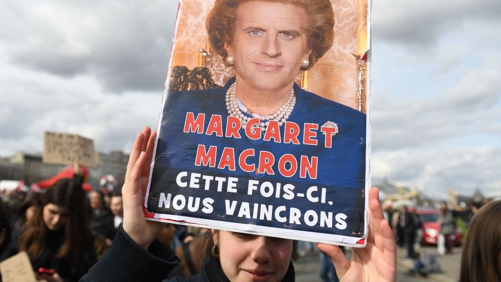 A pensions protester on the streets of Paris holds a placard depicting French president Emmanuel Macron as Margaret Thatcher, with the slogan “This time we will prevail”. Photo: Alain Jocard/AFP