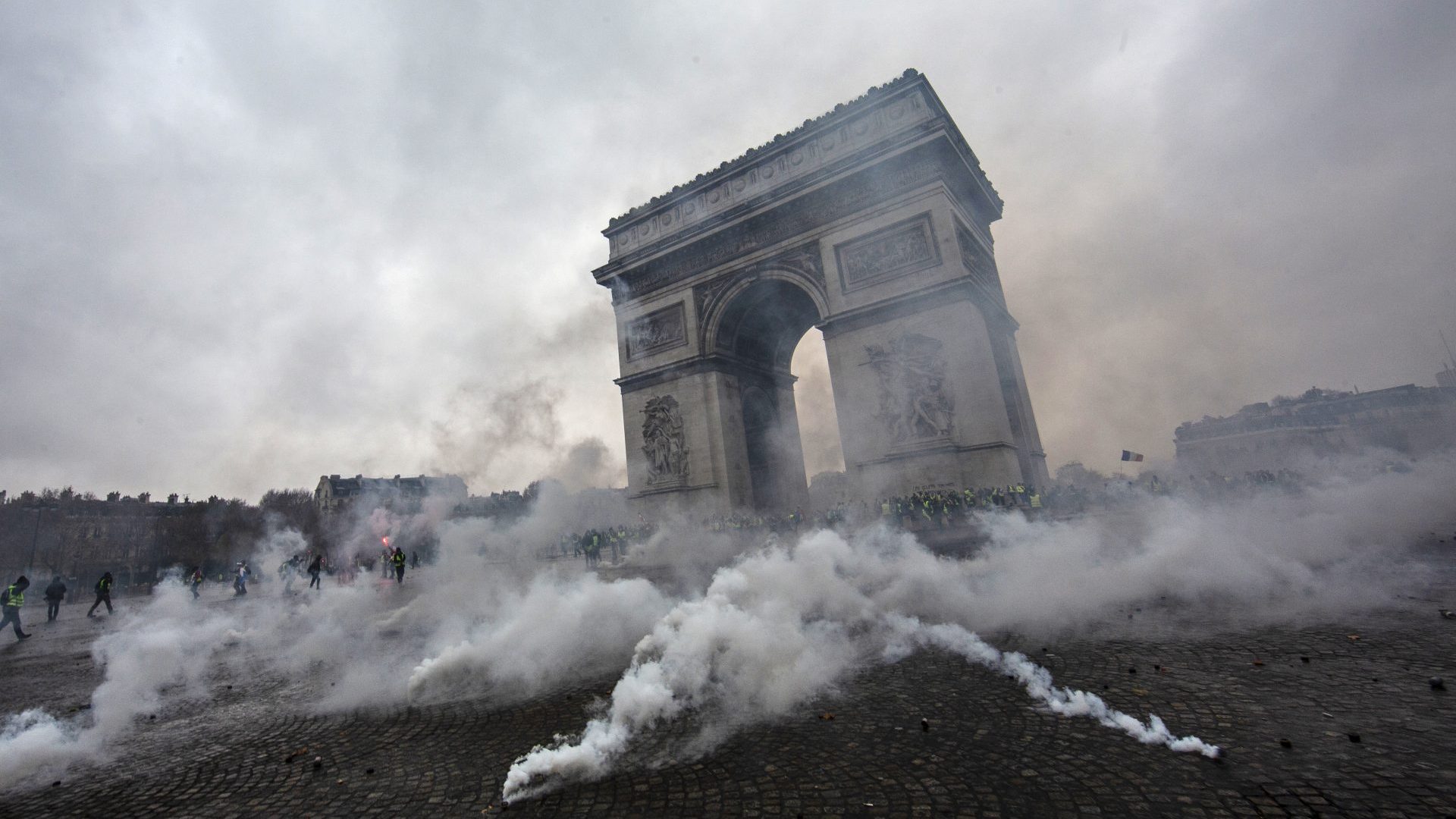 Teargas surrounds riot police as they clash with protesters near the Arc de Triomphe. Photo: Véronique de Viguerie/Getty