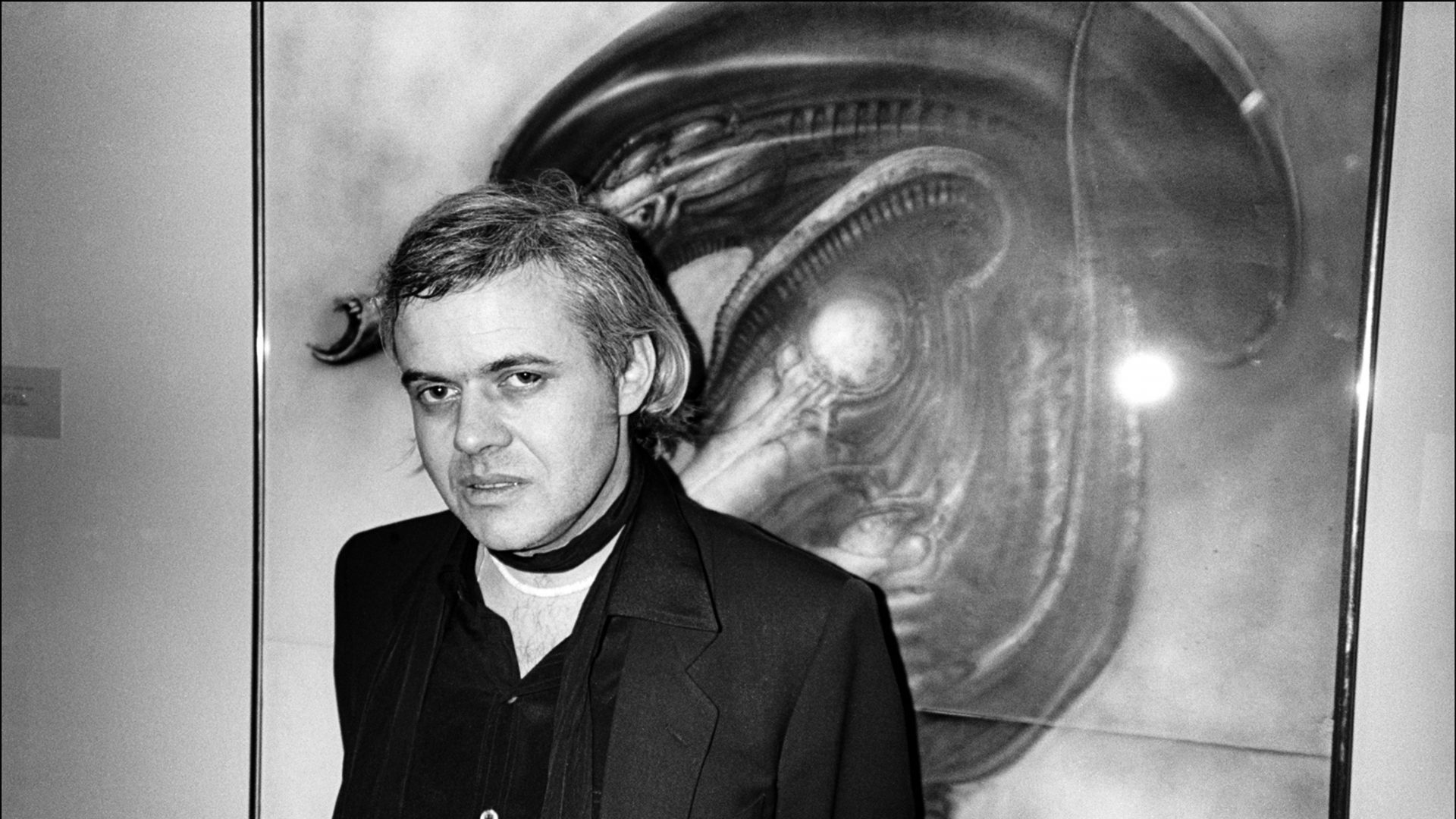 Swiss surrealist 
painter HR Giger 
in front one of his 
Alien works in 
New York, 1980. Photo: Allan 
Tannenbaum/
Getty 